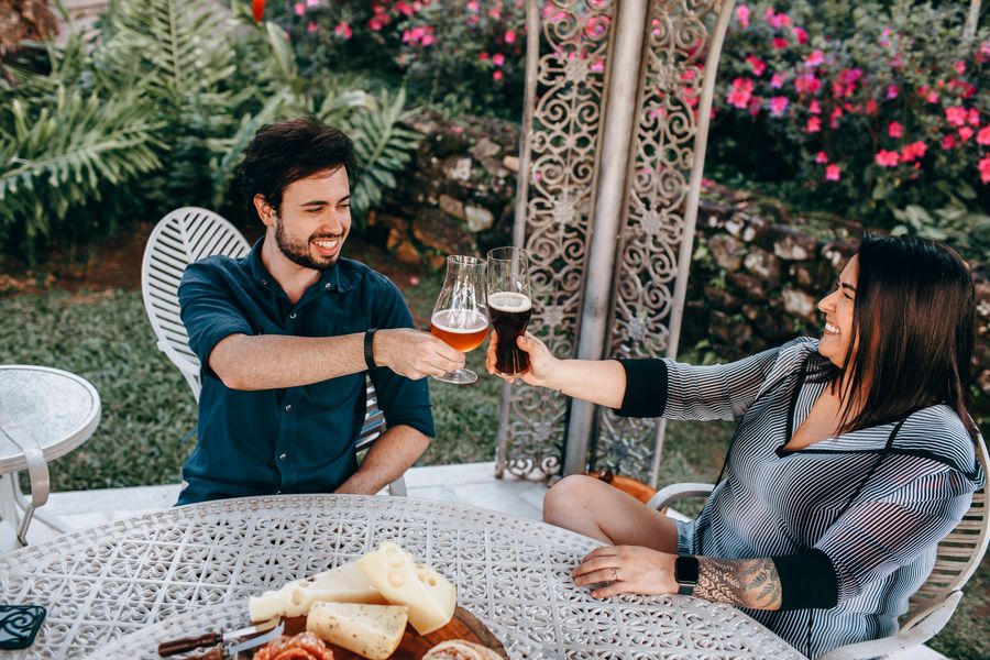 Paar stößt im Garten mit Biergläsern an
