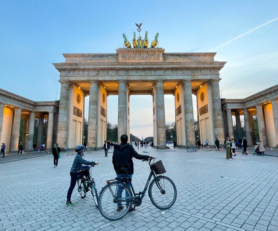 Das Brandenburger Tor in Berlin am Abend, davor Radfahrer