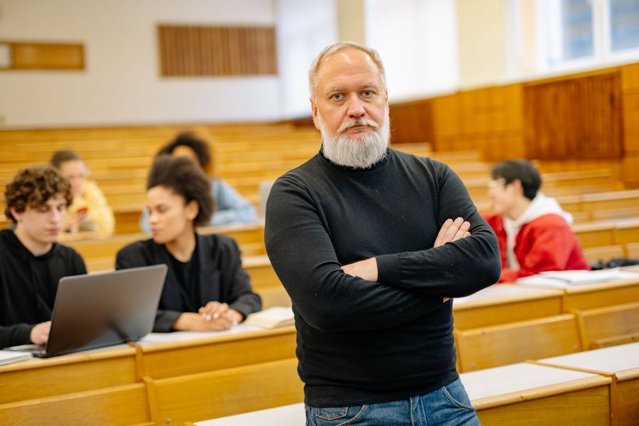 Studierende und eine Lehrkraft in einem Hörsaal